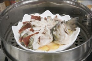 將鱸魚成花狀擺好，將火腿切片放入各縫隙中，放入鍋中隔水蒸12分鐘拿出，撒上蔥花即可。