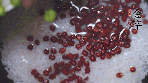 將炒好的食材和大米、紅豆一起放進(jìn)電飯鍋煮。