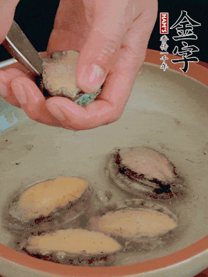 鮑魚加鹽、清水浸泡，用勺子挖出鮑魚肉。