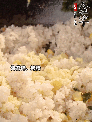 剩米飯下鍋炒散，依次下玉米粒、雞蛋、烤腸、海苔碎翻炒均勻。