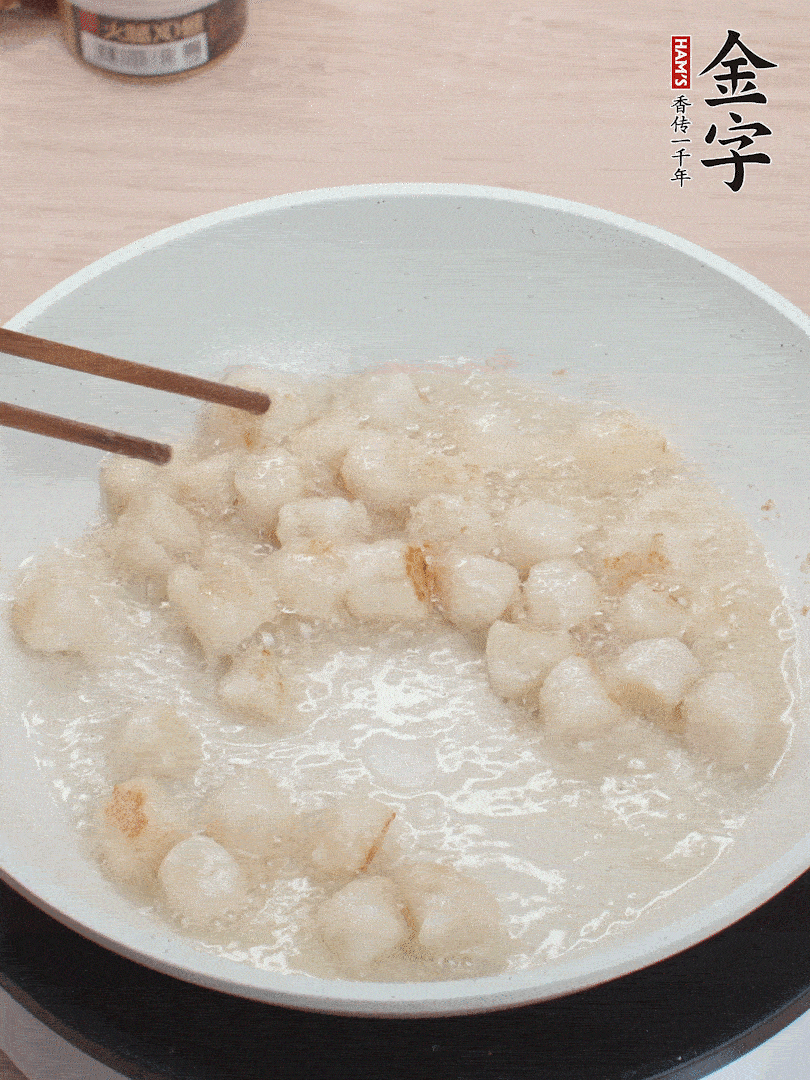 油溫4成熱，鮮貝蘸干淀粉下鍋煎，一面微黃后翻面。
