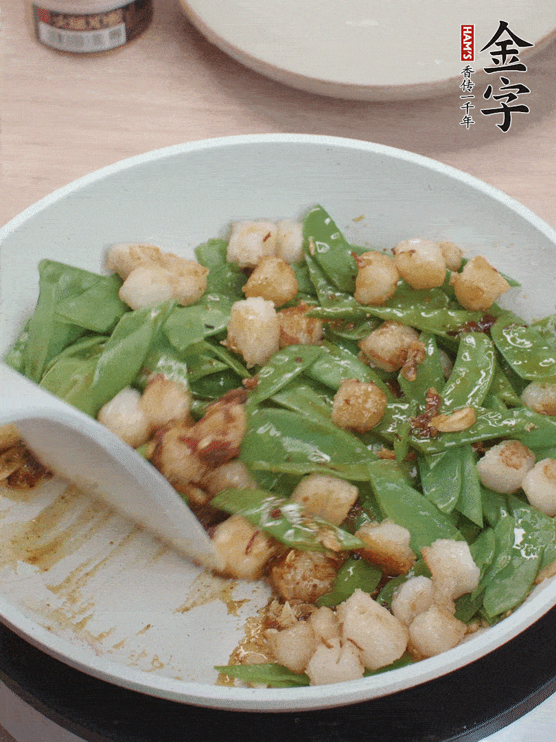 下甜豆莢、鮮貝輕輕翻炒均勻。