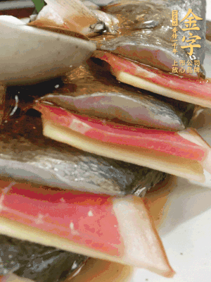 魚肚中塞蔥結(jié)、火腿片，魚身上碼放姜片、火腿片，倒入混合的料汁。