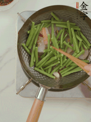 下掰好的缸豆段翻炒，略燜煮。